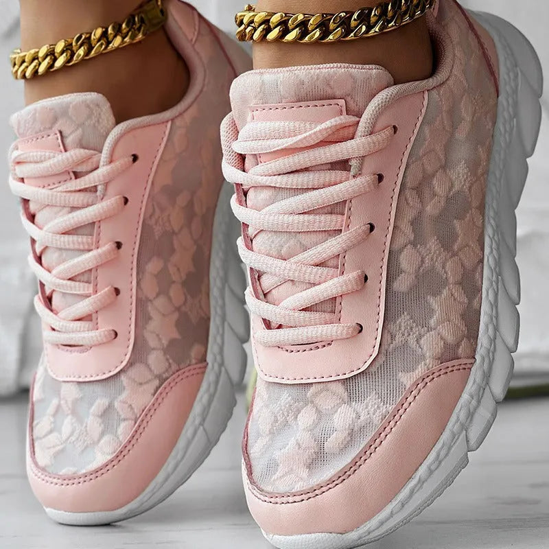 Women's white canvas sports shoes with flat heel and round toe design on neutral background