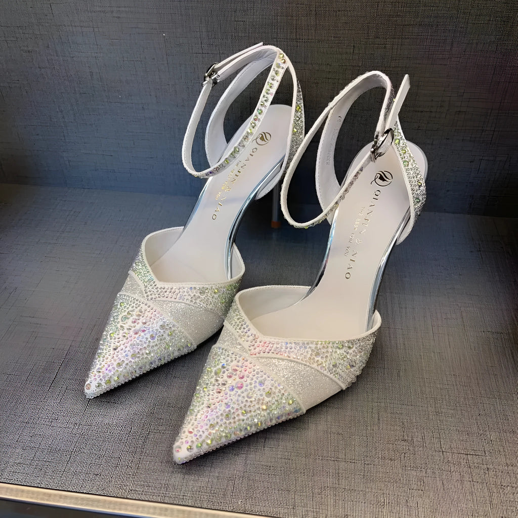 Women's black high heel shoe with stiletto heel, pointed toe, shallow cut, and red sole.