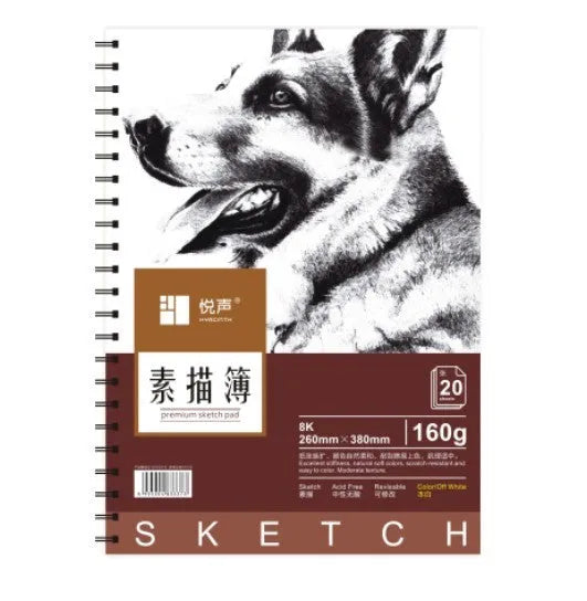 A4 sketch book with spiral coil binding lying open on a table, showing blank heavyweight paper.