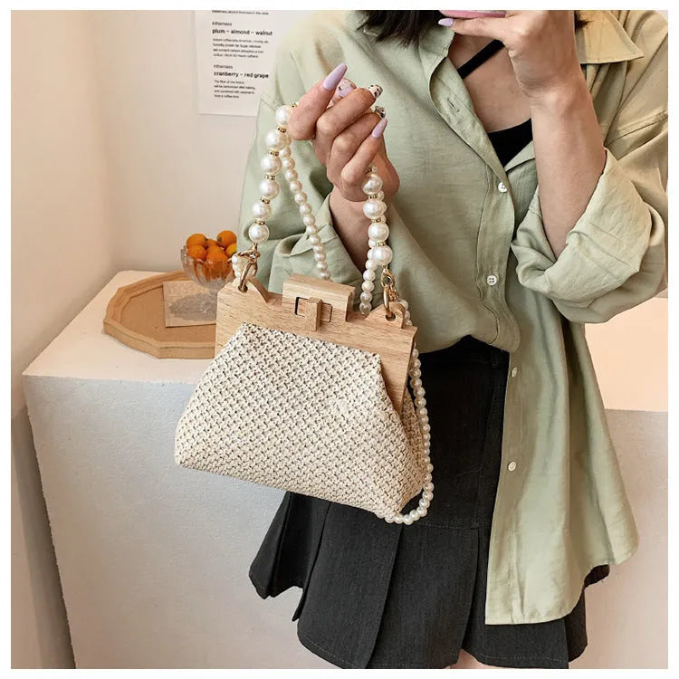Women's soft straw woven horizontal square shoulder bag with pearl chain strap in beige colour.