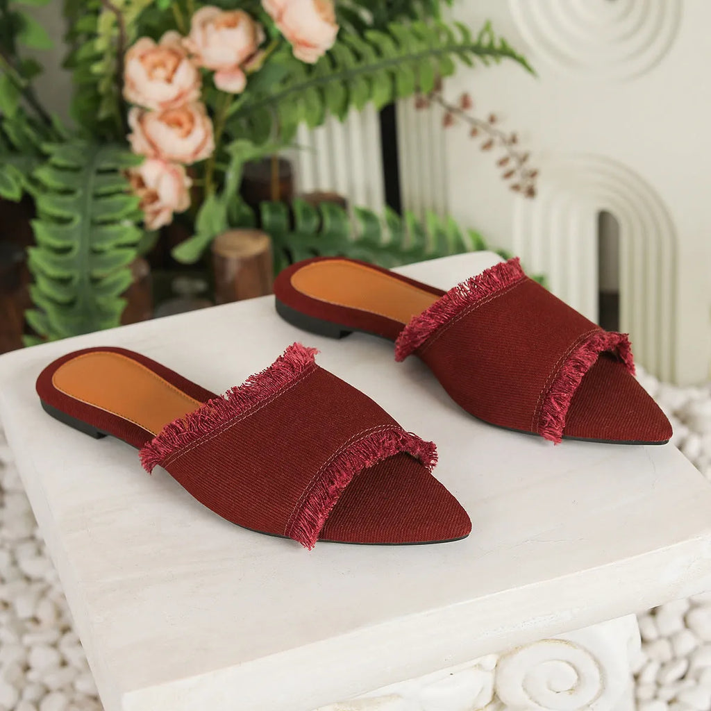 Women's denim flat slippers with a tassel detail and leather lining, shown in apricot colour.