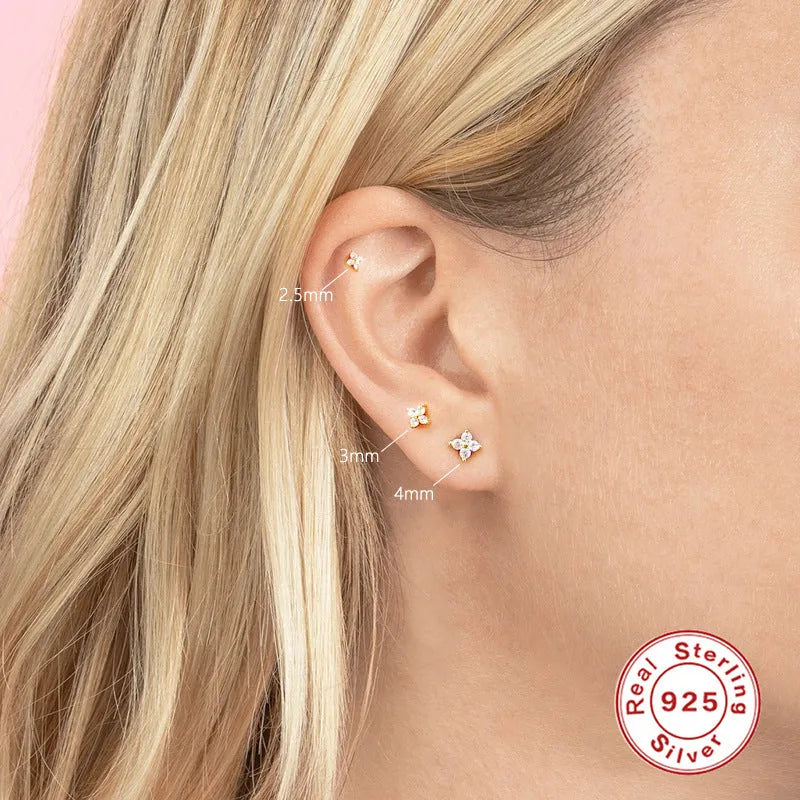 S925 sterling silver stud earrings with crystal flowers in gold and platinum finishes on a grey background.