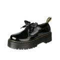 Women's black leather shoes with thick soles, cross straps featuring ribbon details, and lace-up closure
