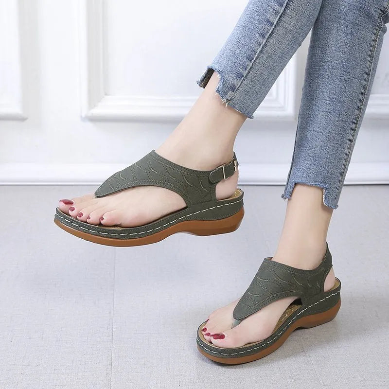 Women's wedge heel flip flop sandals in black with an adjustable back strap and buckle.