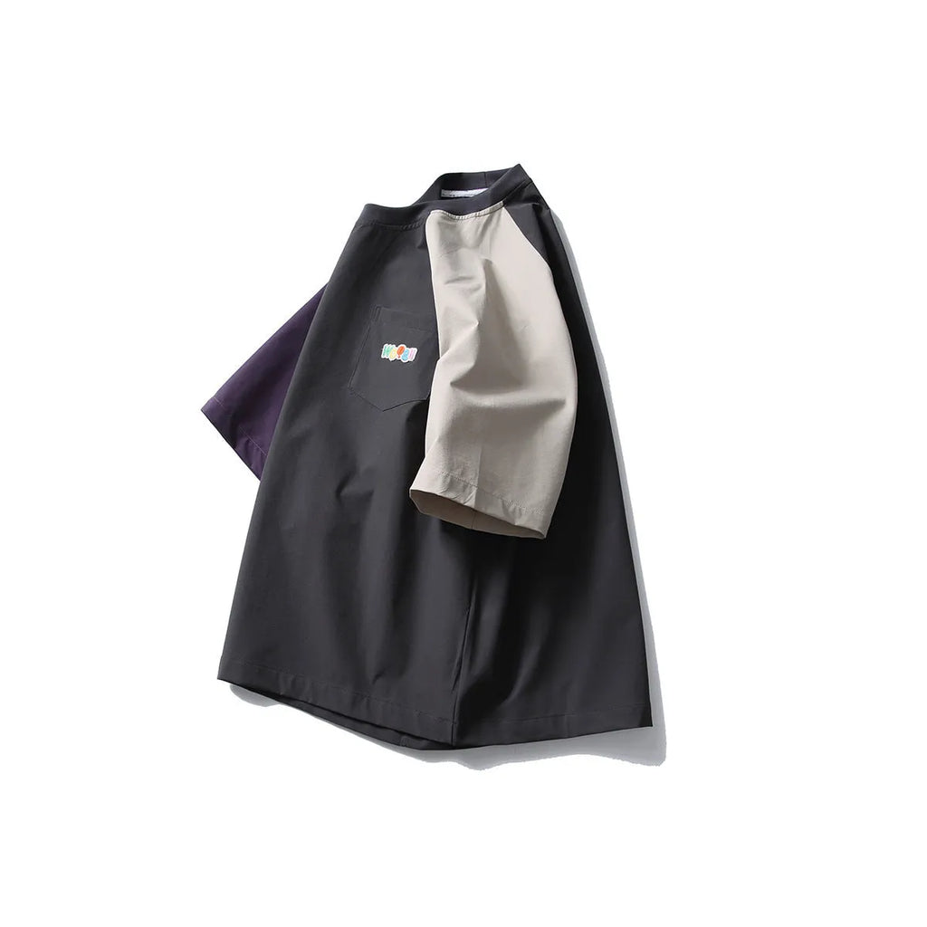 Dark grey loose fit T-shirt with contrast colour raglan sleeves on a hanger.
