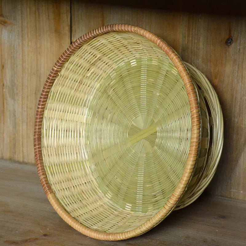 Handmade natural bamboo woven storage basket in three different sizes on a table.