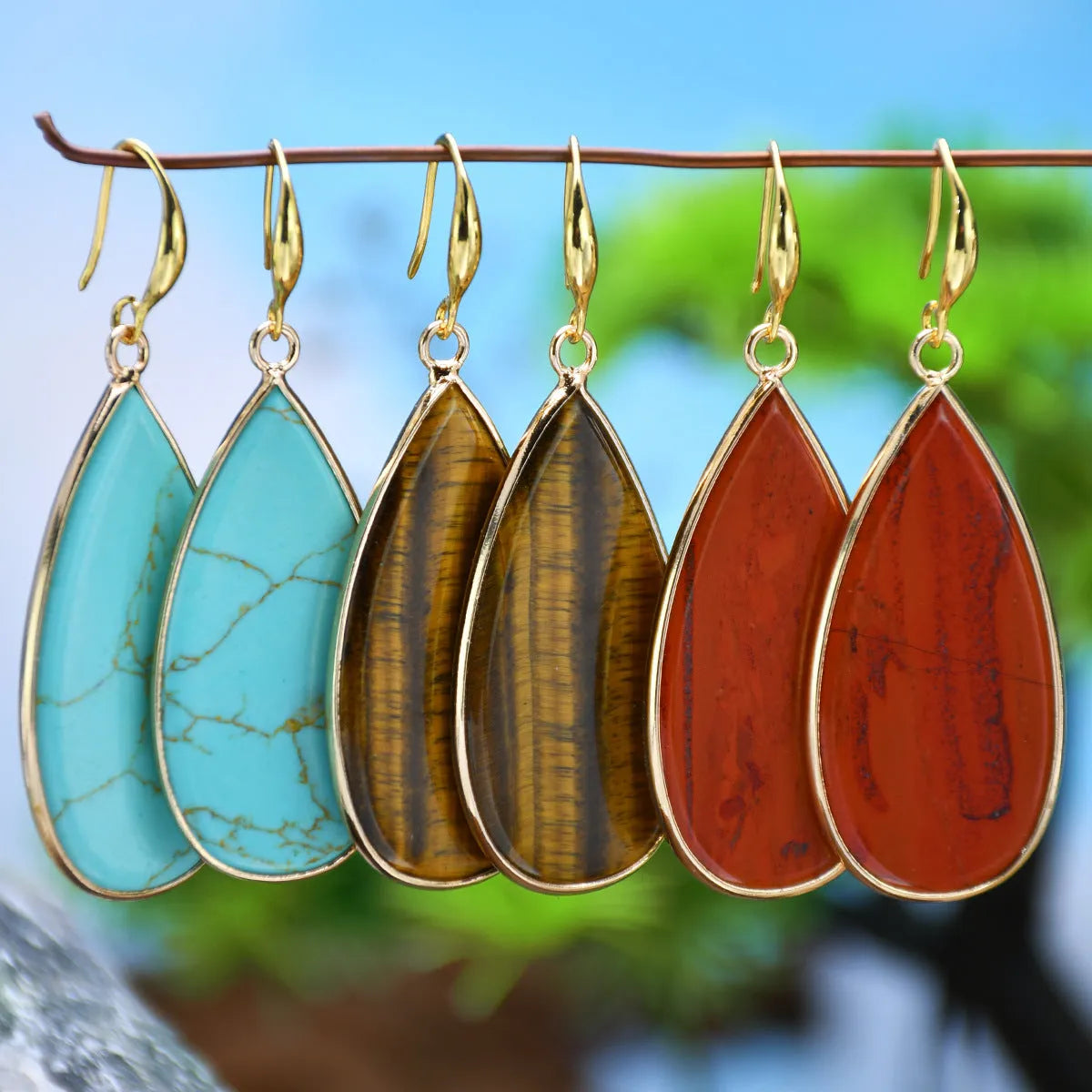 Vintage long drop earrings made from stone with a water droplet texture, shown in Tigereye colour.
