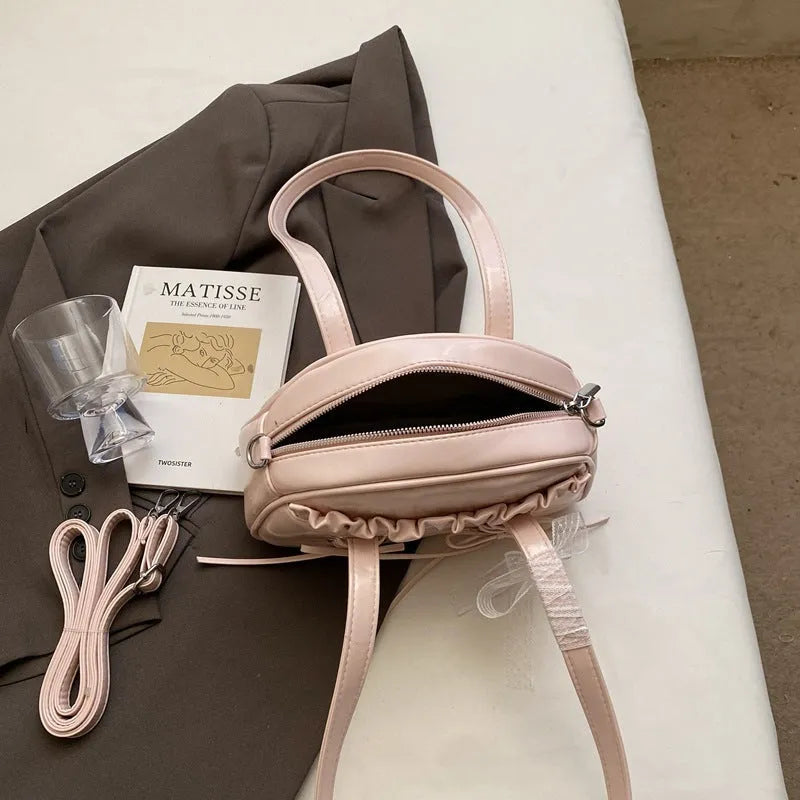 Women's white PU leather shoulder bag with a large bandage bow detail on the front.