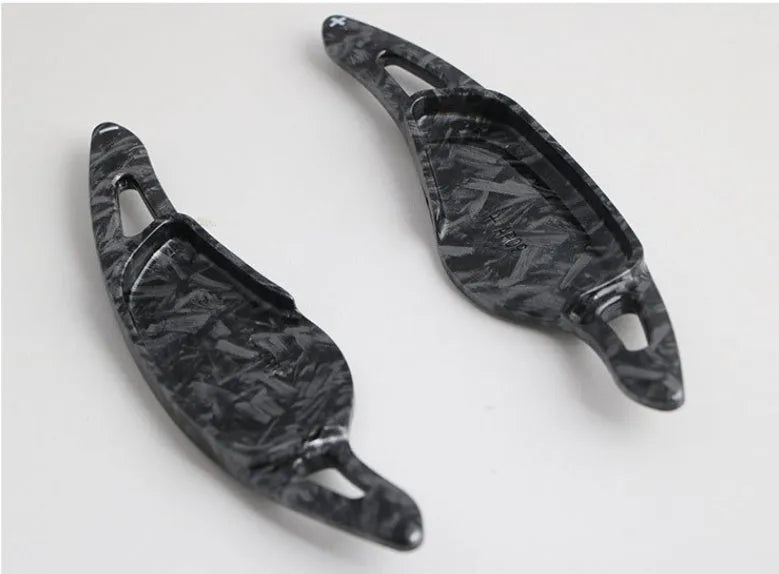 Steering wheel shift paddle modification kit in ABS plastic showing carbon fibre black and red finish options.