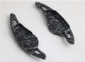 Steering wheel shift paddle modification kit in ABS plastic showing carbon fibre black and red finish options.