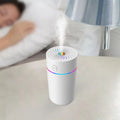 Compact black car USB humidifier with aromatherapy function placed in a vehicle cup holder.