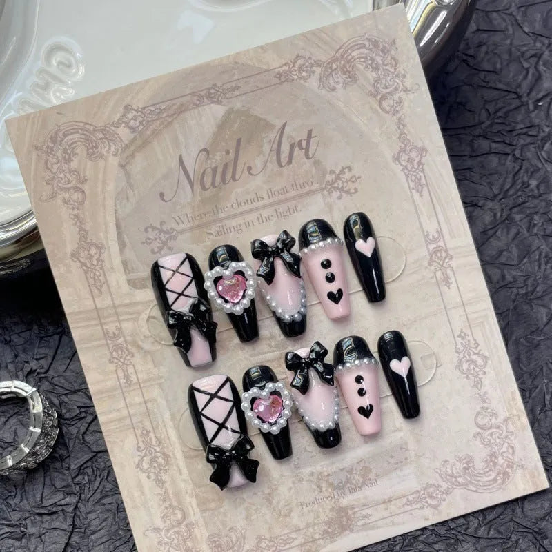 Black and pink peach heart hand-painted press on nails with bow detailing in cat eye gel style