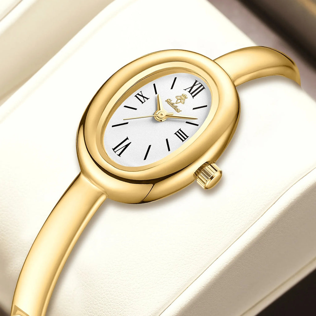 Women's oval retro quartz watch in gold colour with spiral pattern on dial.