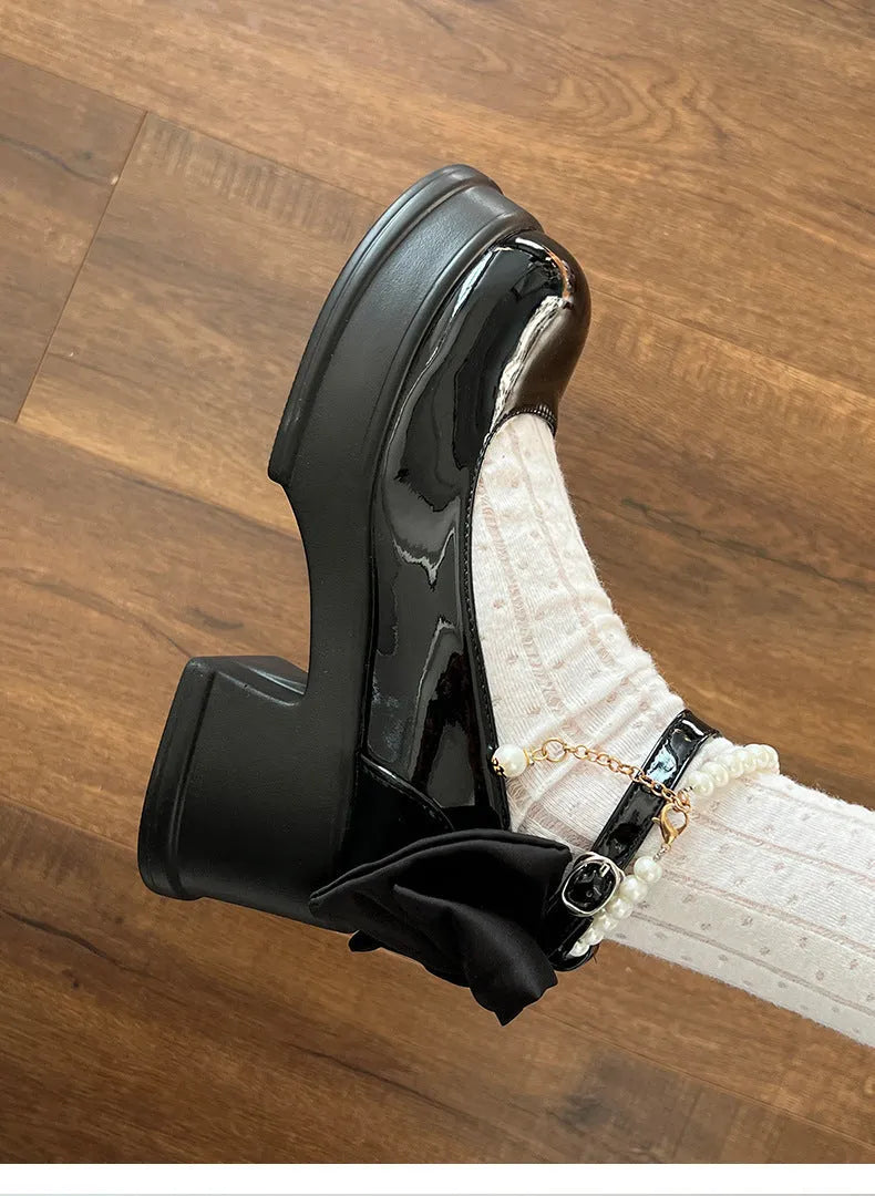 Women's beige and black Mary Jane shoes with a chunky heel and rounded toe.
